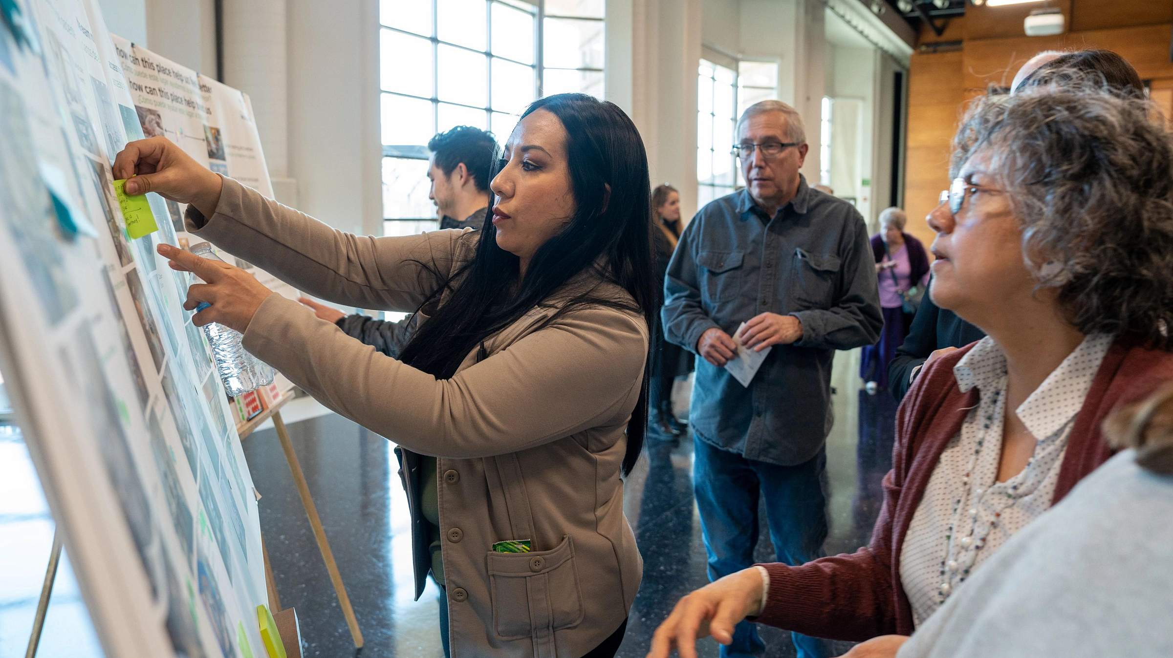 Group of people putting notes on a board.